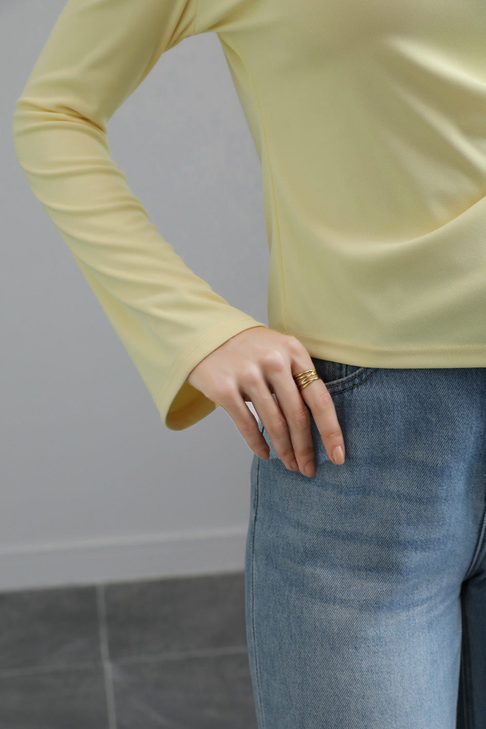 Malbusaat autumn lace up top pale yellow fitted long sleeve top with flared cuff model wearing blue jeans for casual layering