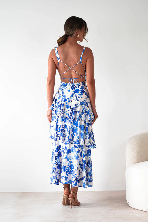 Back view of woman wearing blue and white floral backless deep v plunge summer vacation maxi dress with crisscross straps
