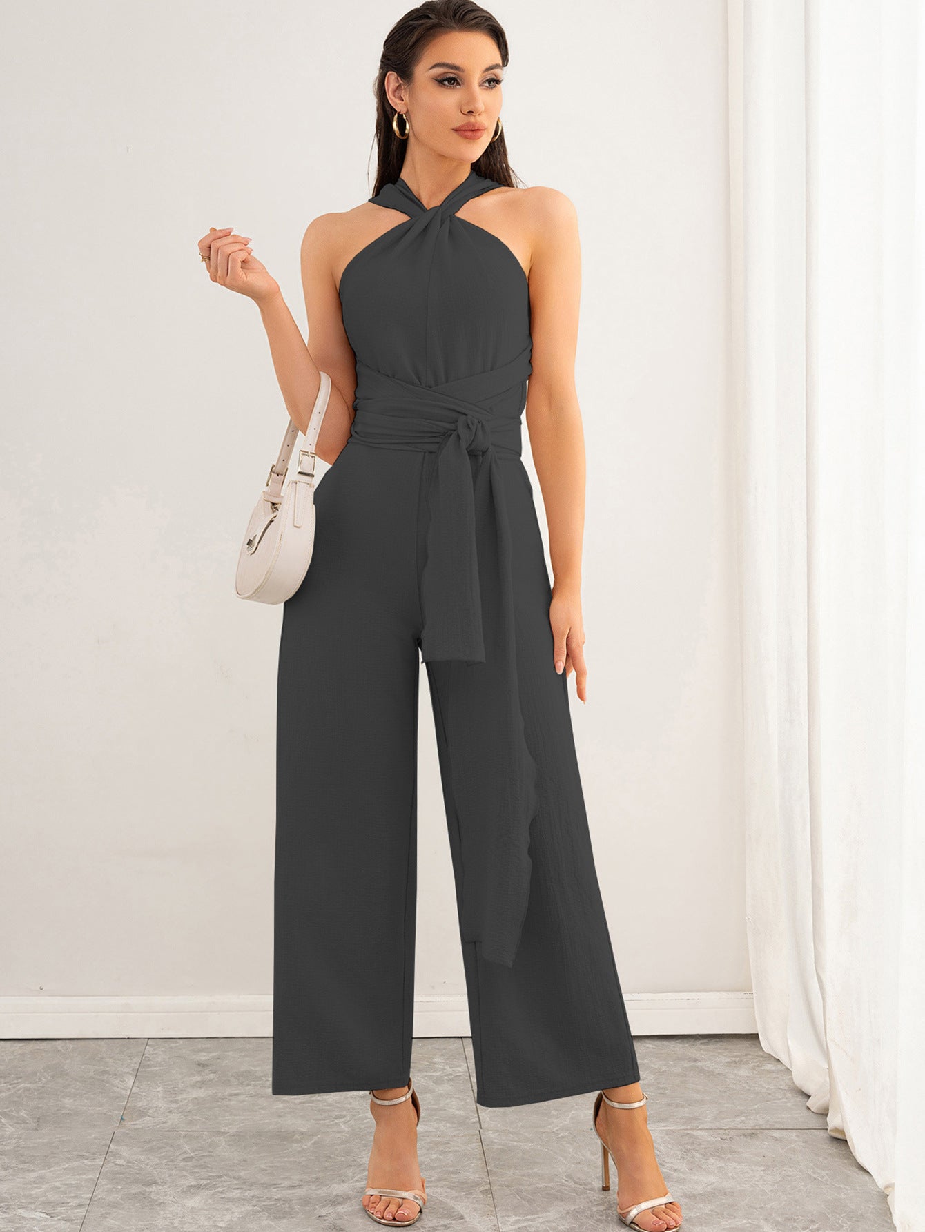 Malbusaat backless women's jumpsuit in charcoal grey halterneck with waist tie and wide leg trousers