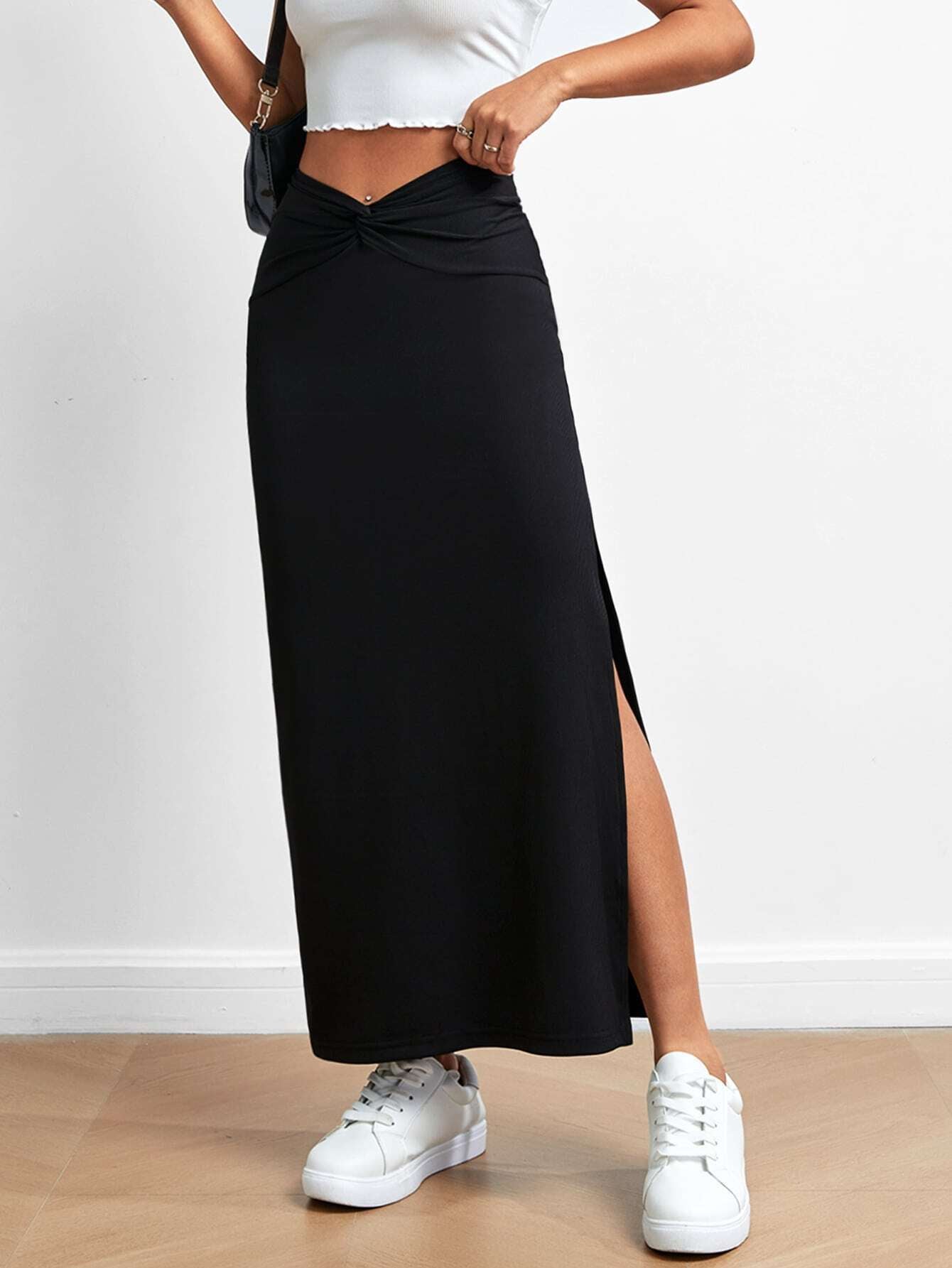 Black drape slit skirt with twisted waistband paired with white crop top and sneakers