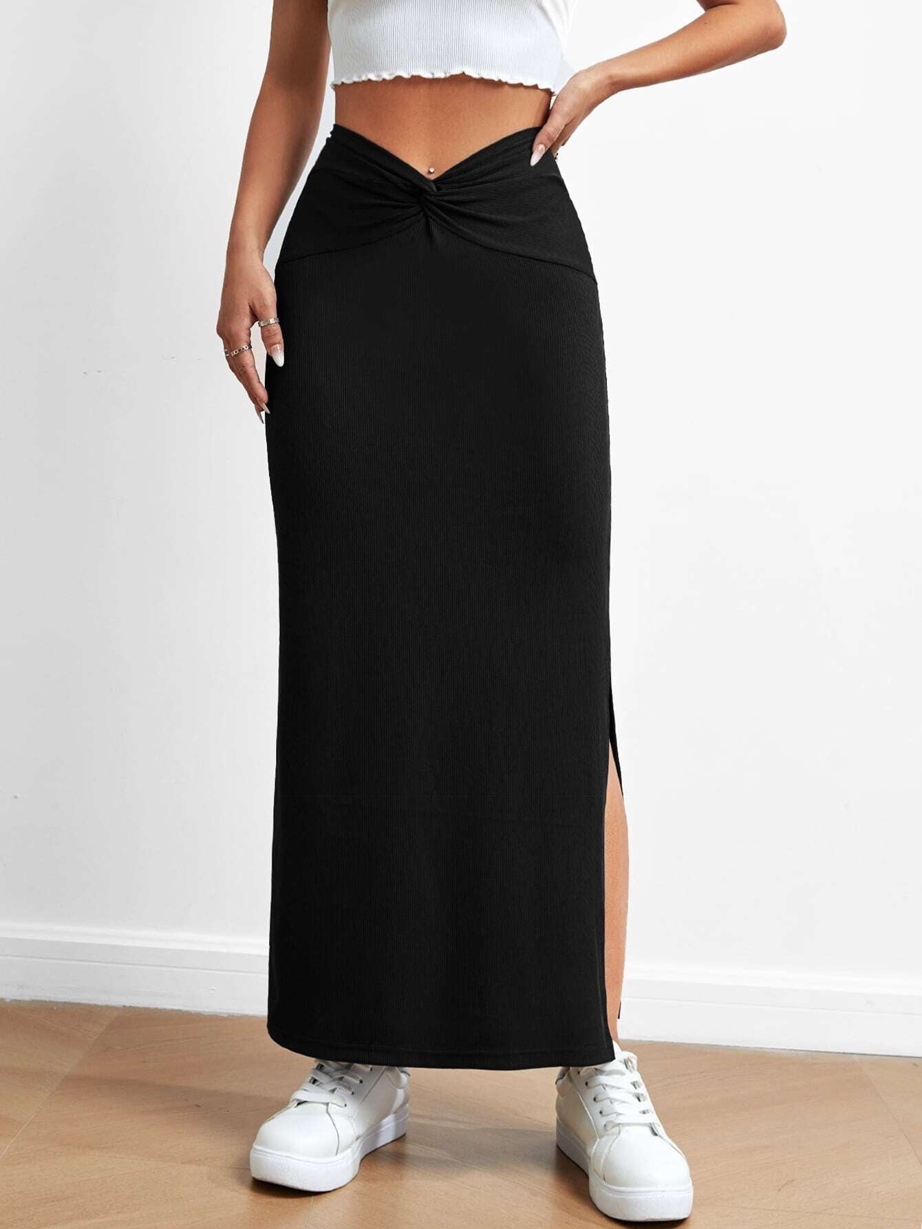 Black drape slit skirt from Malbusaat worn with white crop top and sneakers