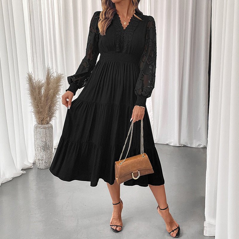 Black elegant lace long sleeve dress with pleated skirt and sheer sleeves worn with brown handbag and sandals