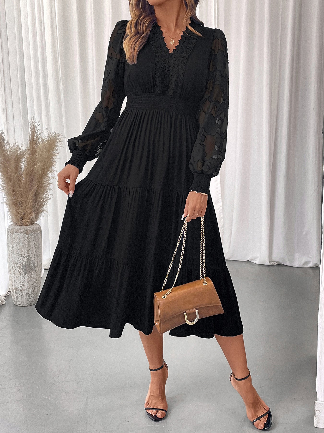 Elegant lace long sleeve dress in black with sheer floral sleeves and pleated skirt by Malbusaat
