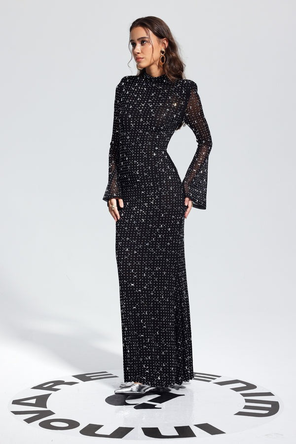 Model in Malbusaat black rhinestone bodycon dress with long sleeves high neck and floor length fitted silhouette