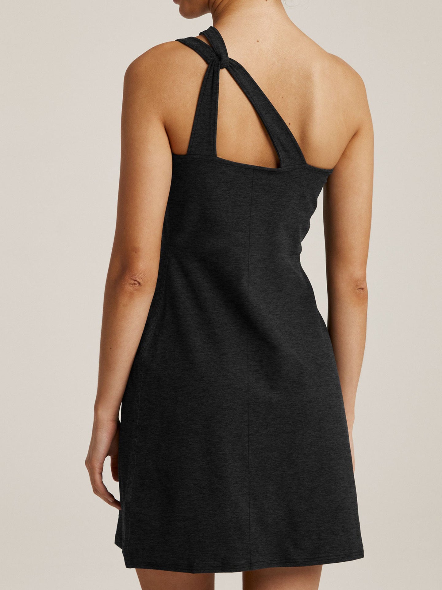 Back view of Malbusaat black sling mini dress with knotted shoulder straps and simple silhouette