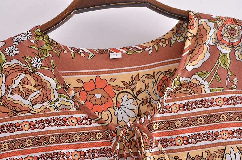 Close-up of Malbusaat bohemian maxi dress for women with floral and geometric patterns in warm tones