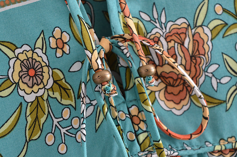 Close-up of floral pattern and drawstring with wooden beads on bohemian maxi dress for women by Malbusaat