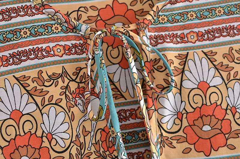 Close-up of Malbusaat bohemian maxi dress for women with floral and geometric patterns and bow tie detail