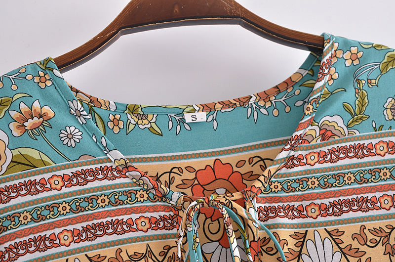 Close-up of Malbusaat bohemian maxi dress for women featuring floral and geometric patterns with tie neck detail