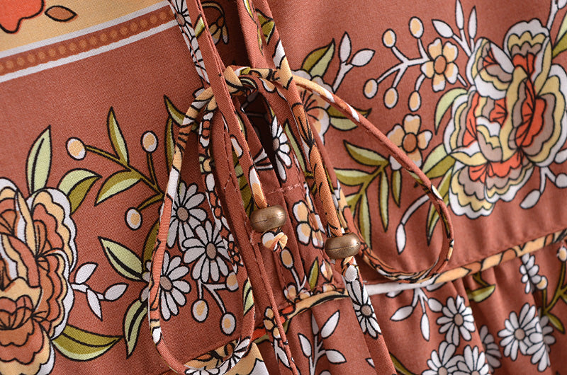 Close-up of a bohemian maxi dress for women with floral patterns and tie details by Malbusaat
