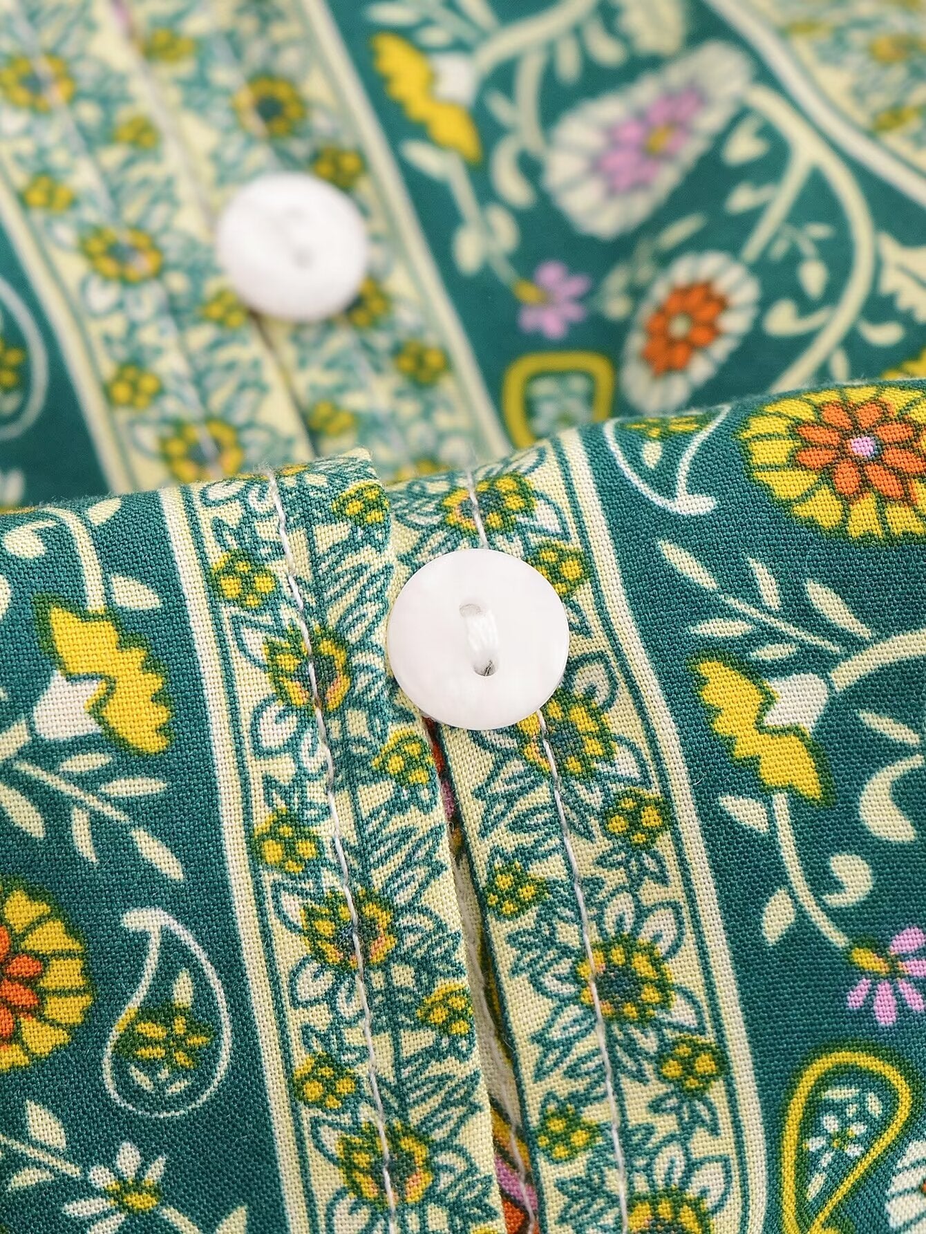 Close-up of Malbusaat rayon floral maxi dress fabric with white buttons and colourful floral print