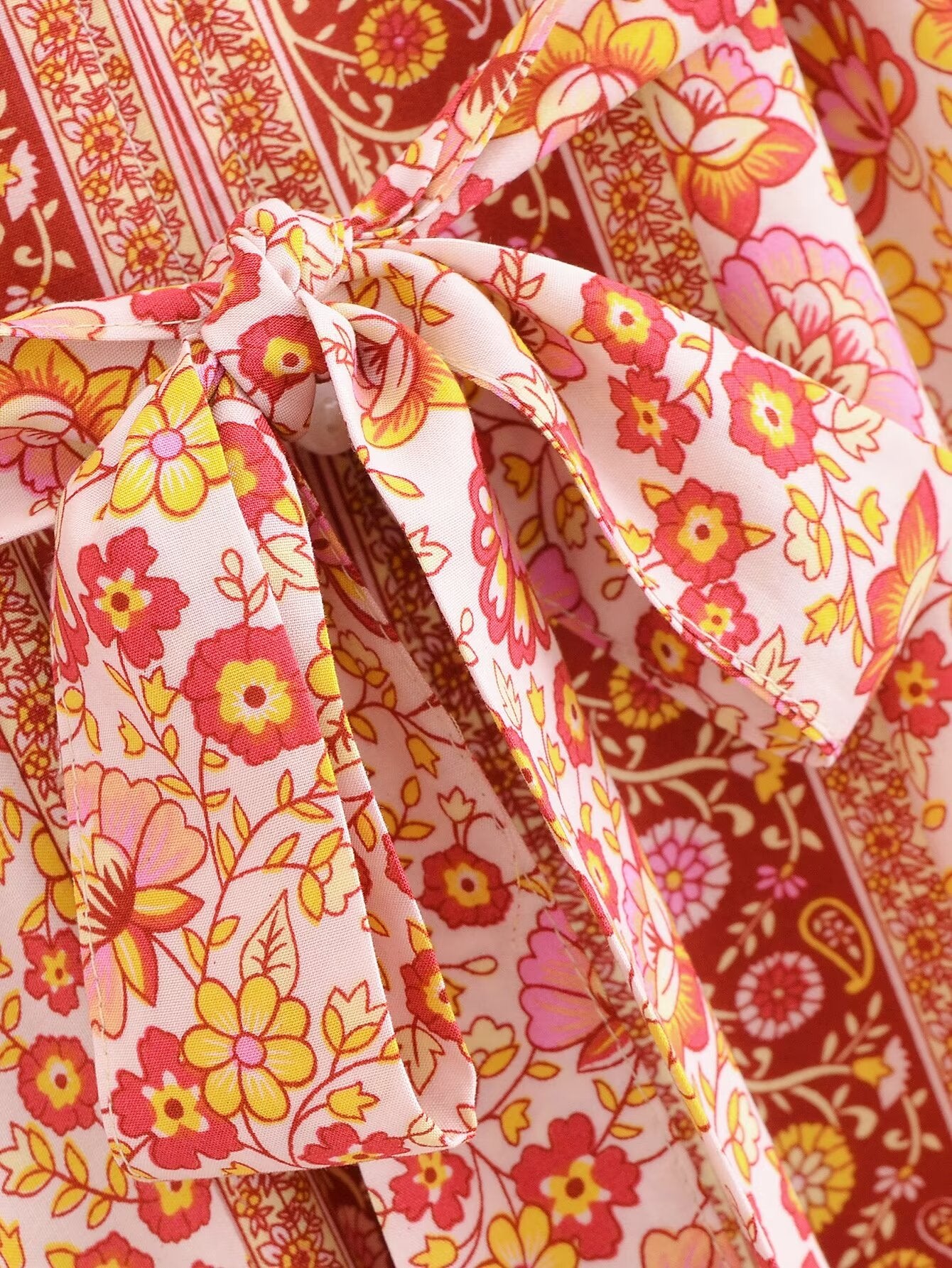 Close-up of Malbusaat rayon floral maxi dress featuring vibrant pink and yellow flowers with a tied bow detail