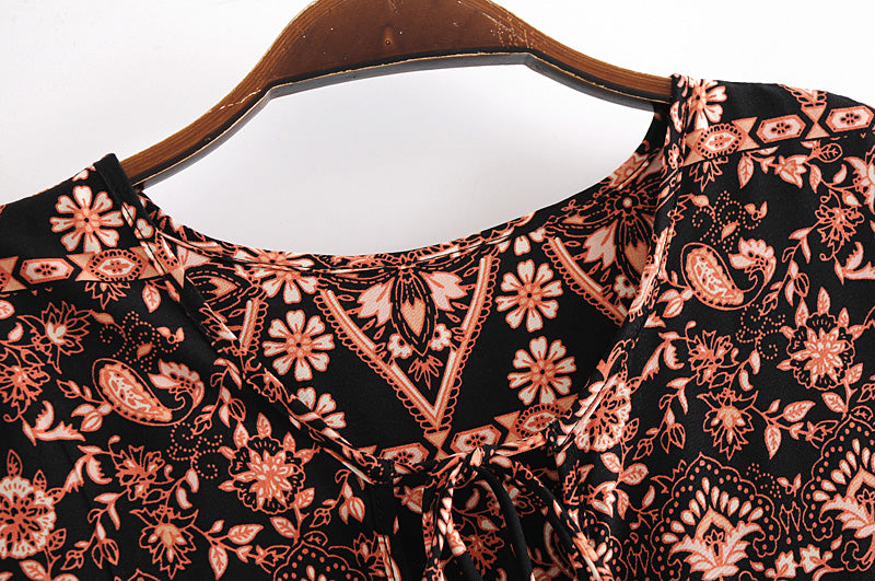 Close-up of black and peach floral pattern on loose fit printed holiday dress by Malbusaat