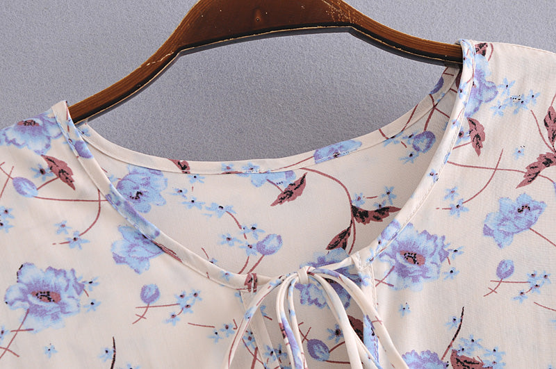 Close-up of Malbusaat elegant floral maxi dress neckline with blue flower print on cream fabric