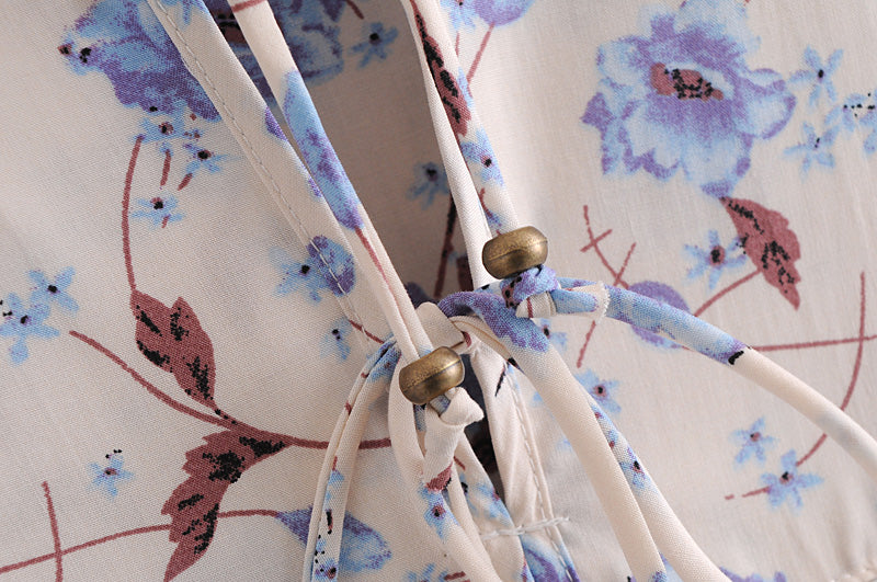 Close-up of elegant floral maxi dress fabric with blue and pink flowers and drawstring detail by Malbusaat
