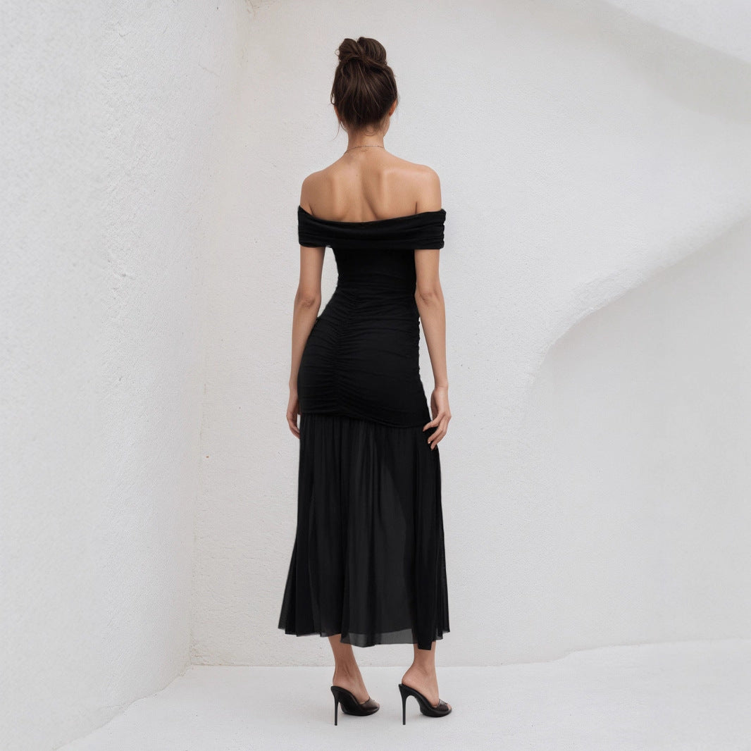 Back view of elegant black off shoulder maxi dress worn with black heels in a minimal white setting