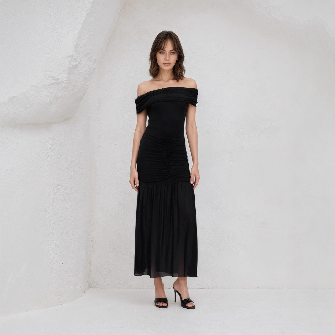 Elegant black off shoulder maxi dress worn by model with ruched bodice and flowy skirt