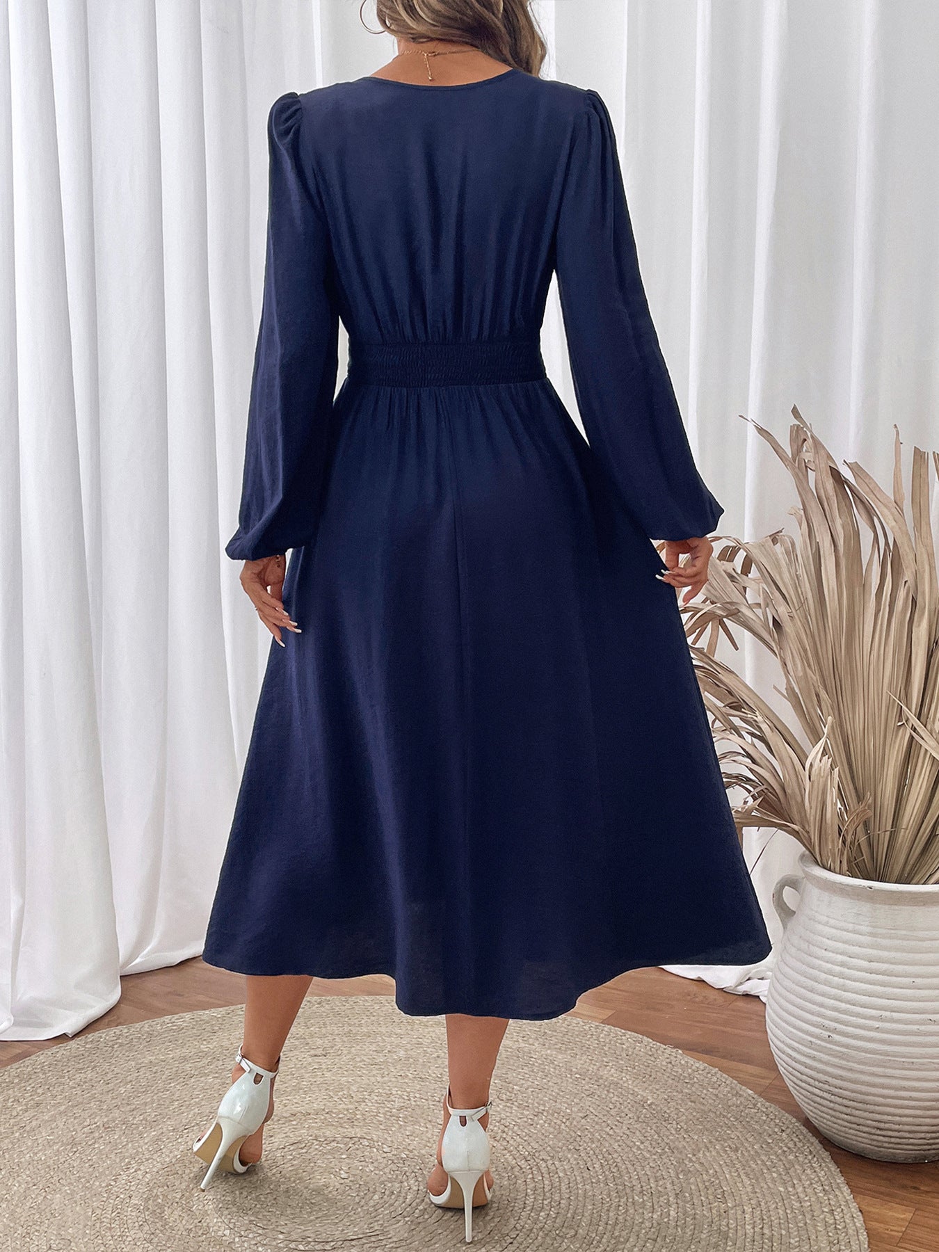 Back view of Malbusaat embroidered v neck midi dress in navy with long sleeves and a flowing skirt