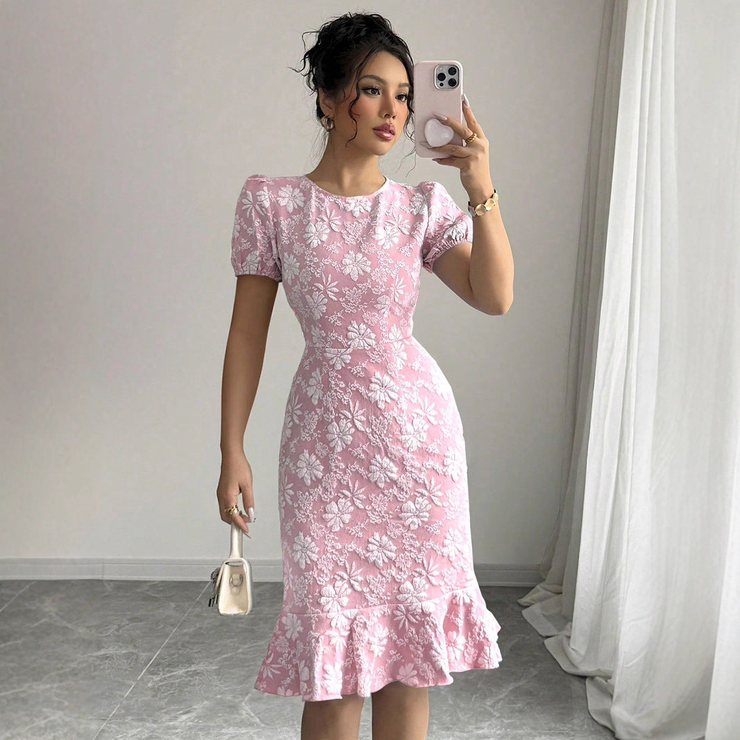 Woman wearing pink floral fishtail bodycon dress with puff sleeves taking a mirror selfie indoors