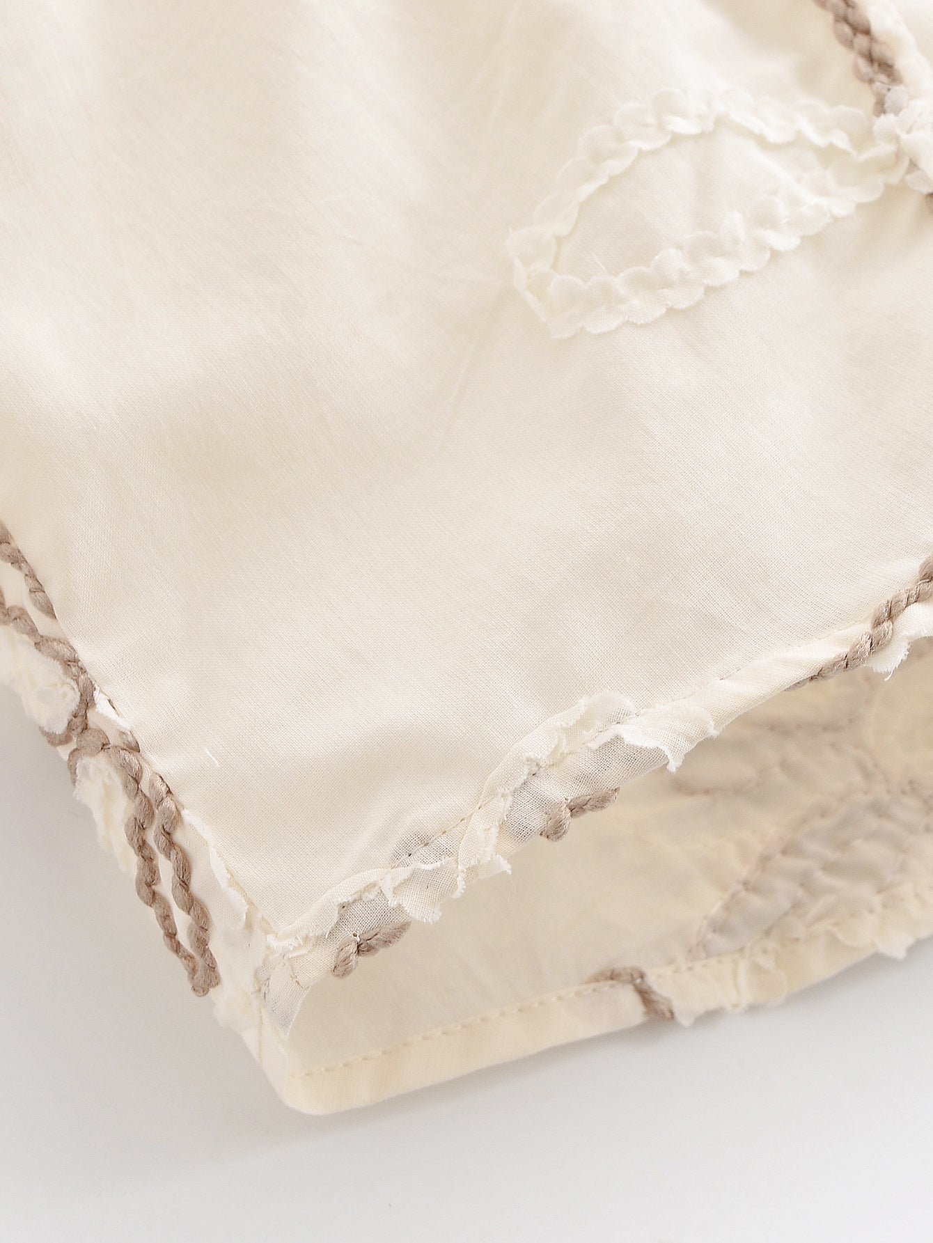 Close-up of cream floral mini shirt for women with delicate embroidered edges by Malbusaat