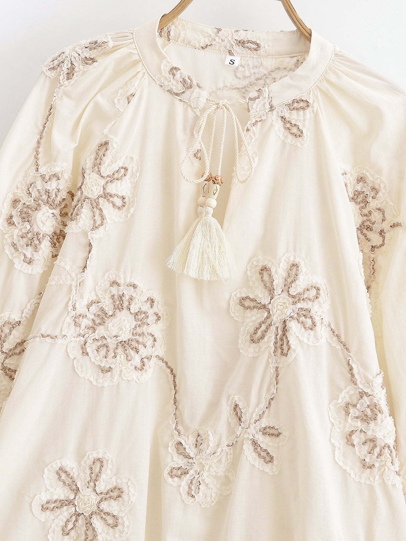 Malbusaat floral mini shirt for women in cream with embroidered flower patterns and tassel detail