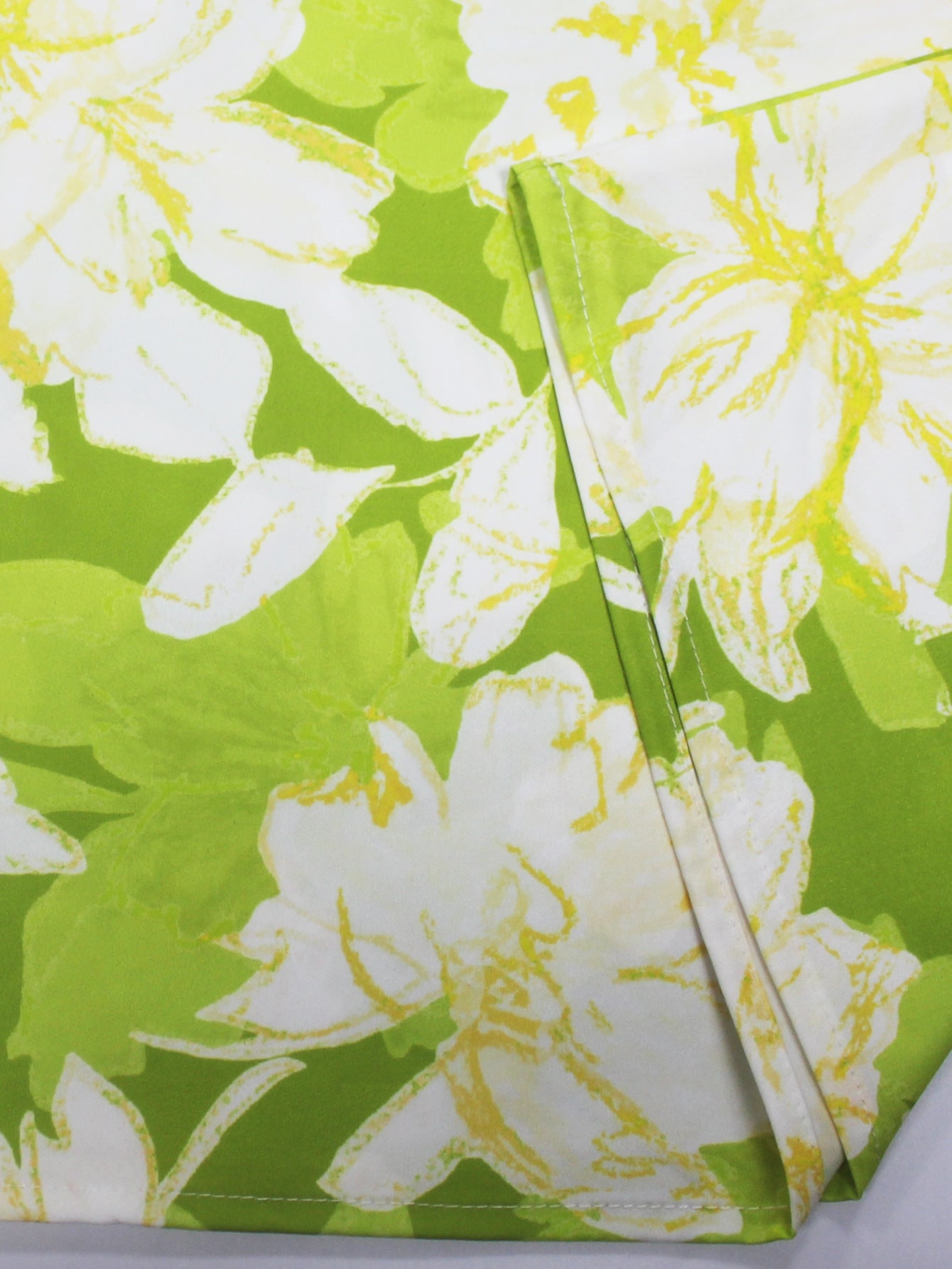 Close-up of green and white floral fabric with detail of short sleeved ladies jumpsuit outfit by Malbusaat