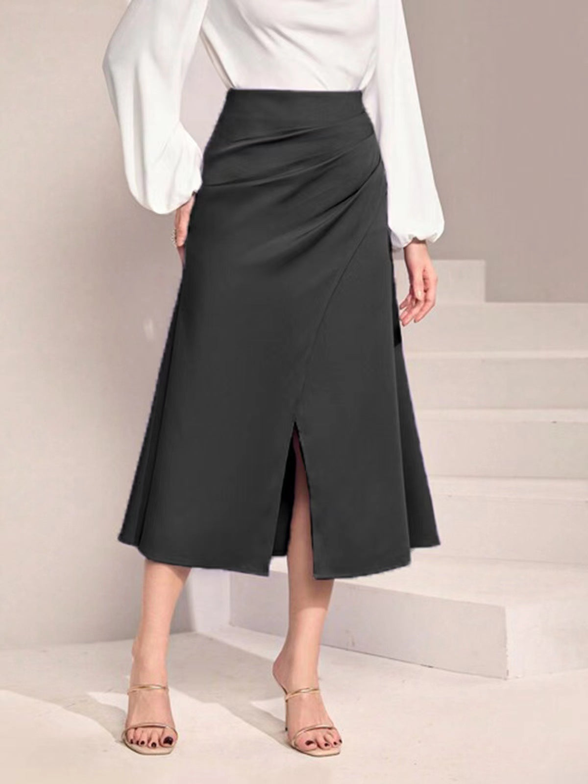 Malbusaat black high waist satin skirt with front slit styled with white blouse and heels