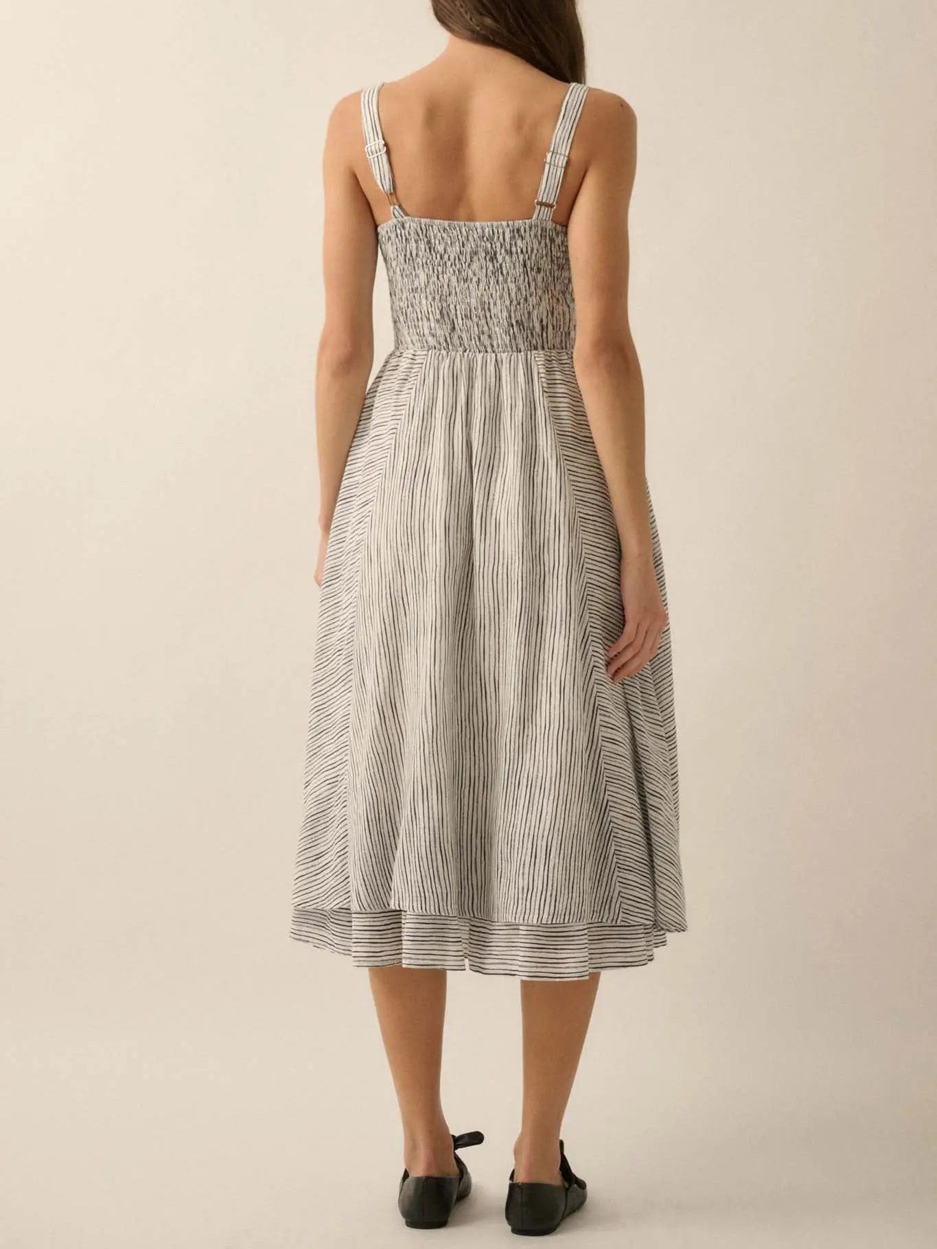 Back view of ladies summer striped cotton dress by Malbusaat featuring adjustable straps and a smocked bodice