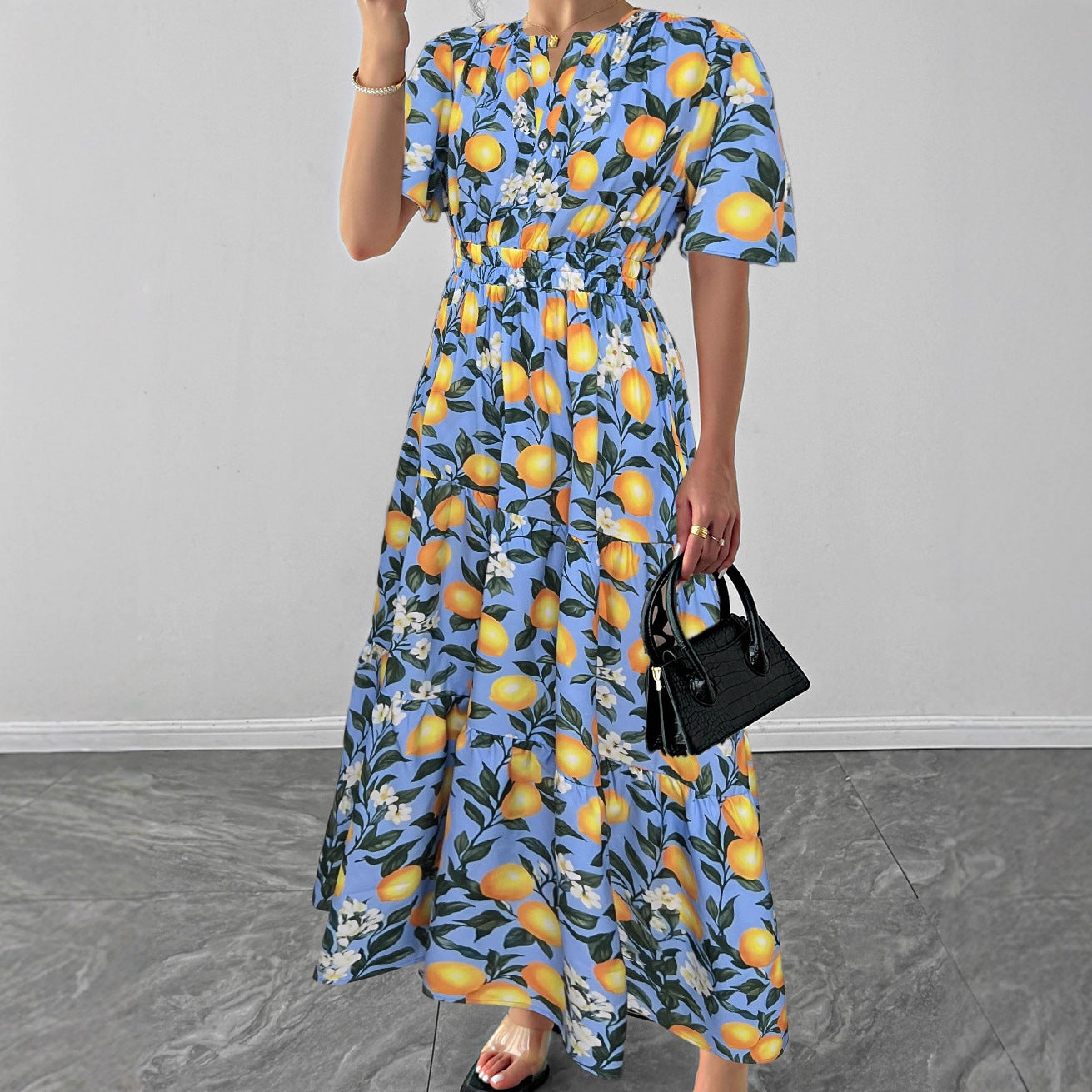 Malbusaat lemon print maxi dress featuring a vibrant blue background and floral design