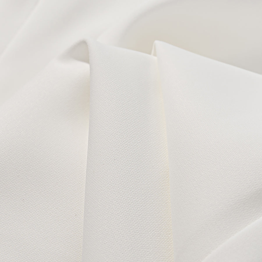 Close-up of white fabric texture for elegant lace maxi dress by Malbusaat