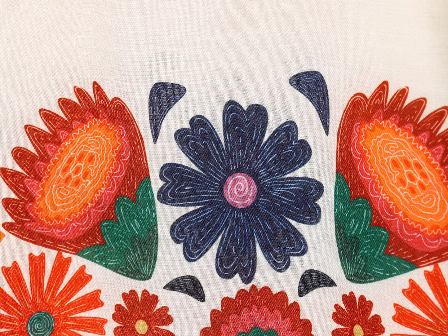 Close-up of colorful floral embroidery designs on white fabric from Malbusaat floral spaghetti strap slim fit maxi