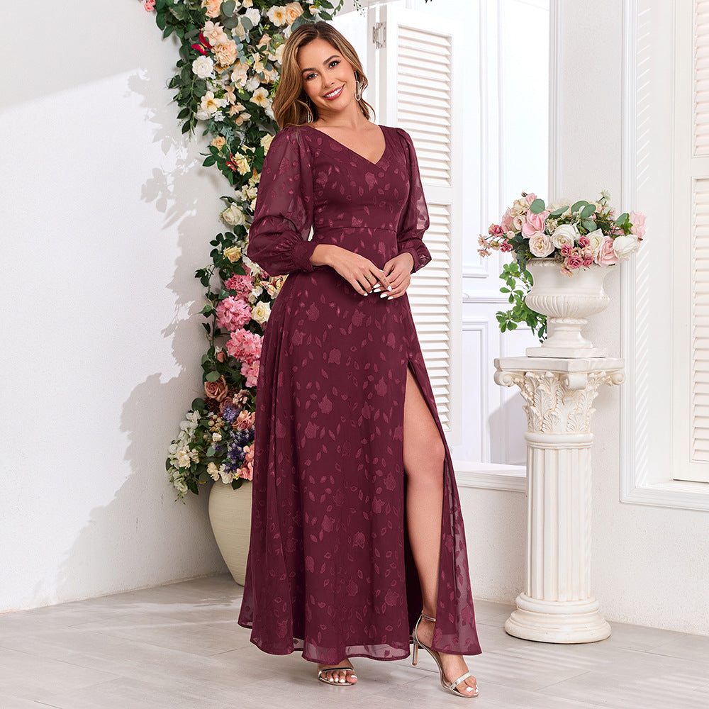 Malbusaat lace maxi dress with high slit in deep burgundy worn by model with floral background