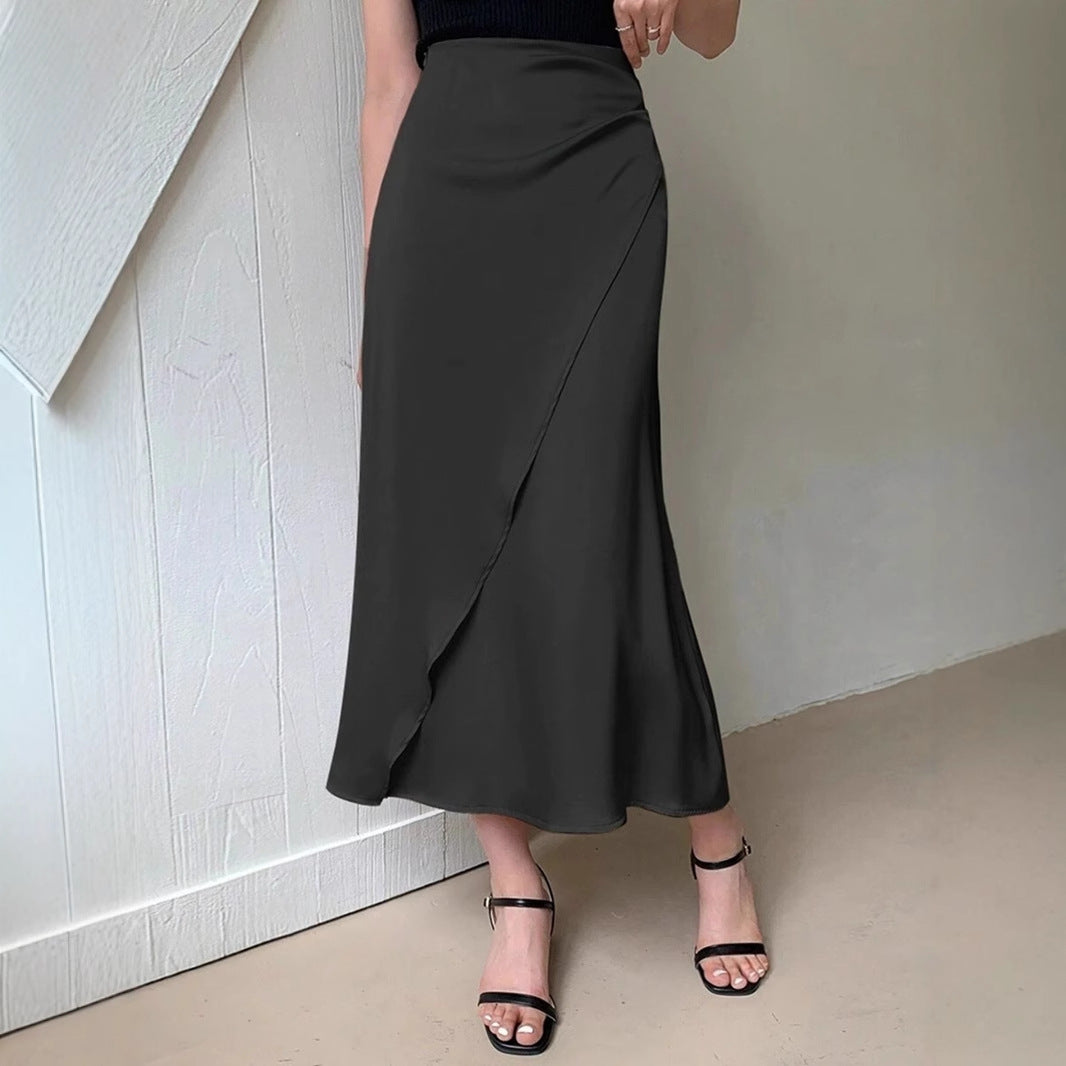 Black satin midi skirt for women with a wrap design, worn with black strappy heels
