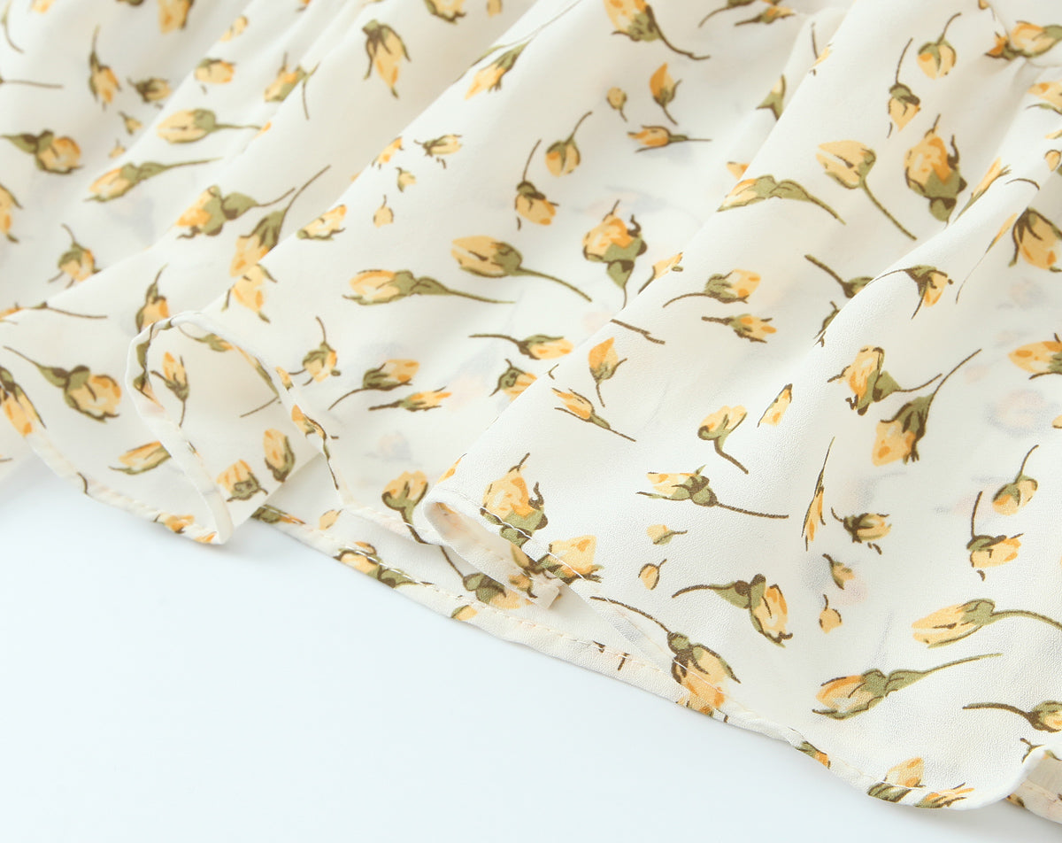 Close-up of Malbusaat summer floral puff sleeve dress fabric with yellow floral print on white background