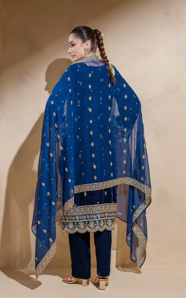 Elegant midnight blue velvet Pakistani suit with intricate gold embroidery and a flowing dupatta