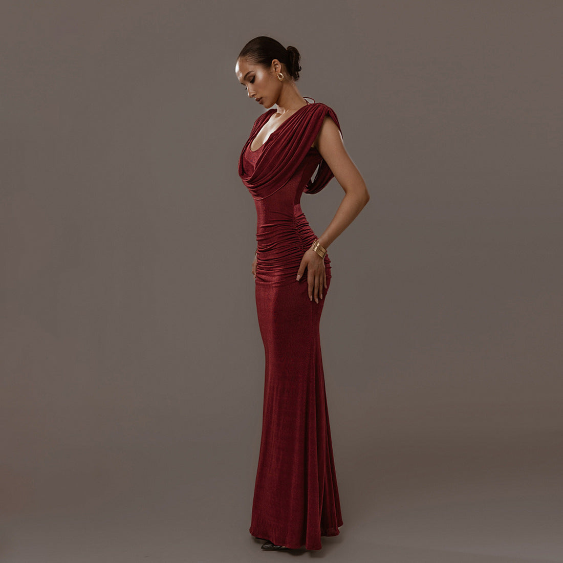 Elegant burgundy pleated maxi dress UK with a fitted silhouette and draped neckline for special occasions