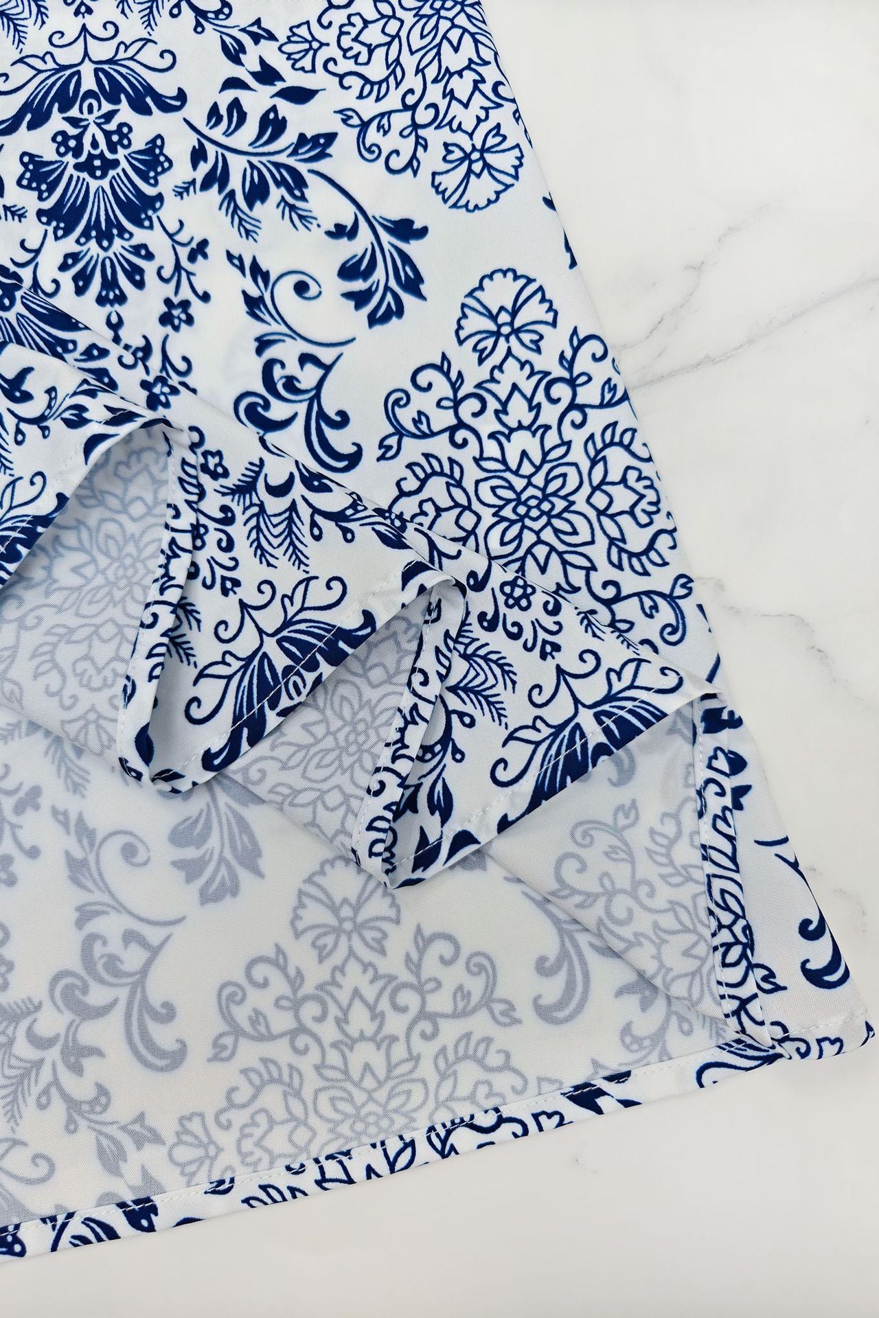 Close-up of a blue and white printed lace up maxi dress showcasing intricate floral patterns