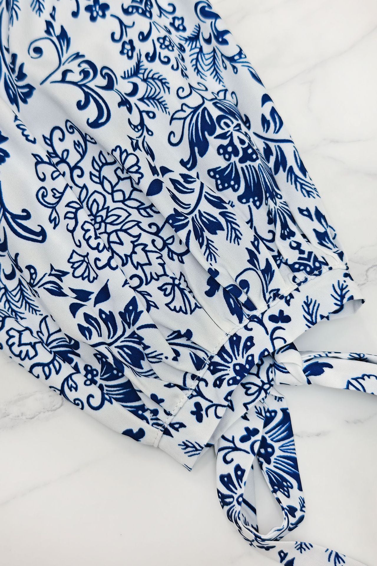 Malbusaat printed lace up maxi dress featuring a floral blue and white pattern with a tie detail