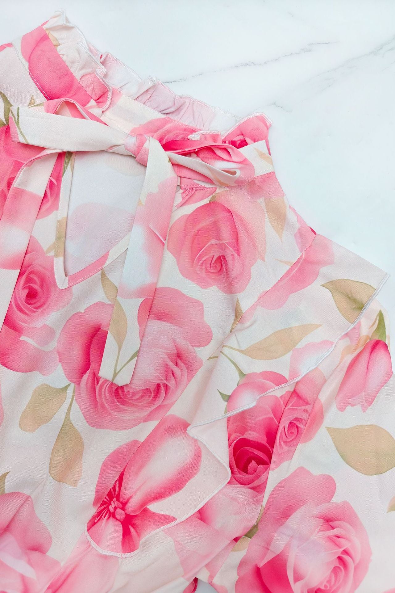 Malbusaat printed pleated maxi dress featuring a floral design with pink roses and a tie neck detail
