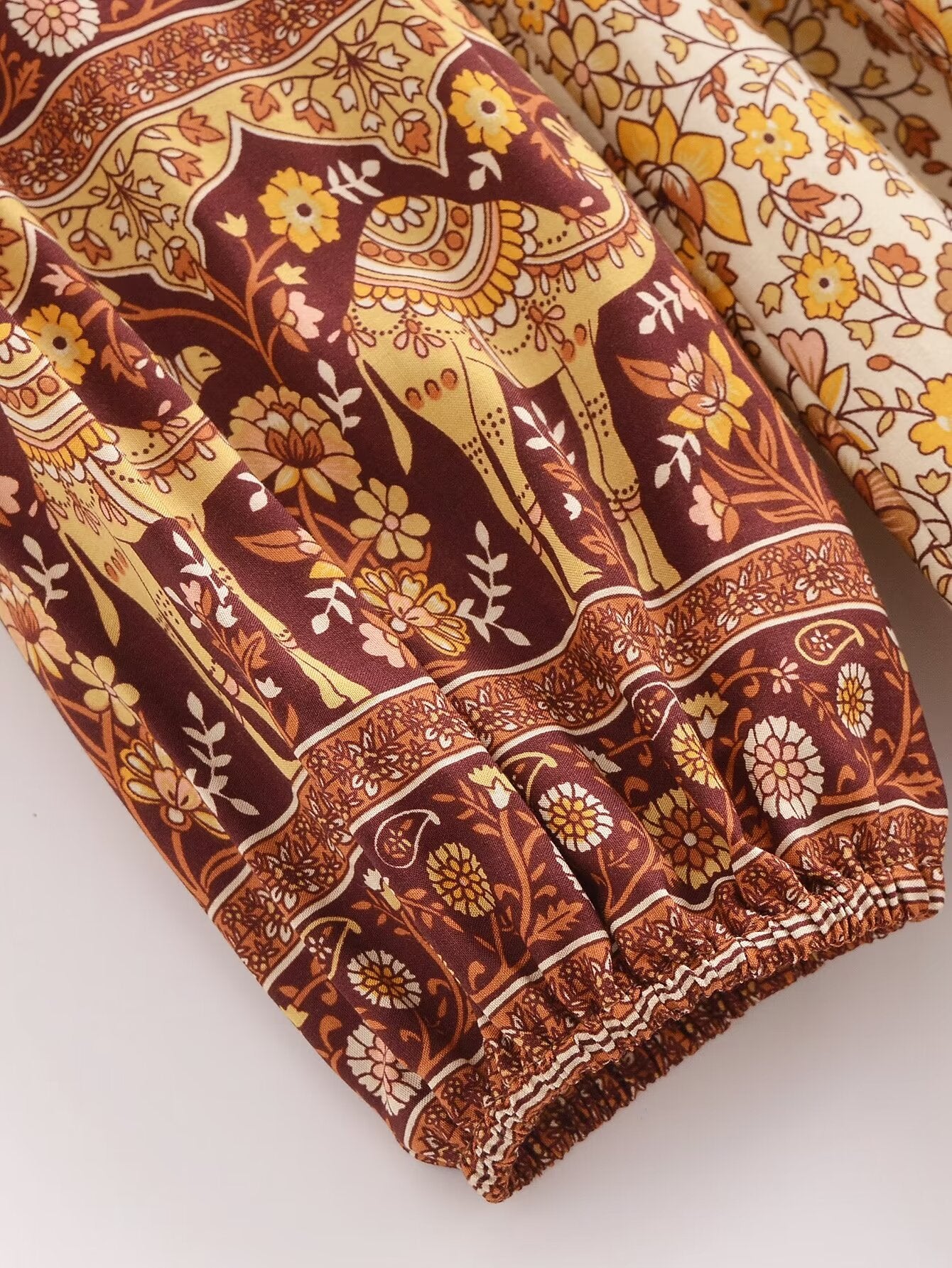 Close-up of printed rayon maxi dress for women featuring brown and yellow floral and animal motifs by Malbusaat