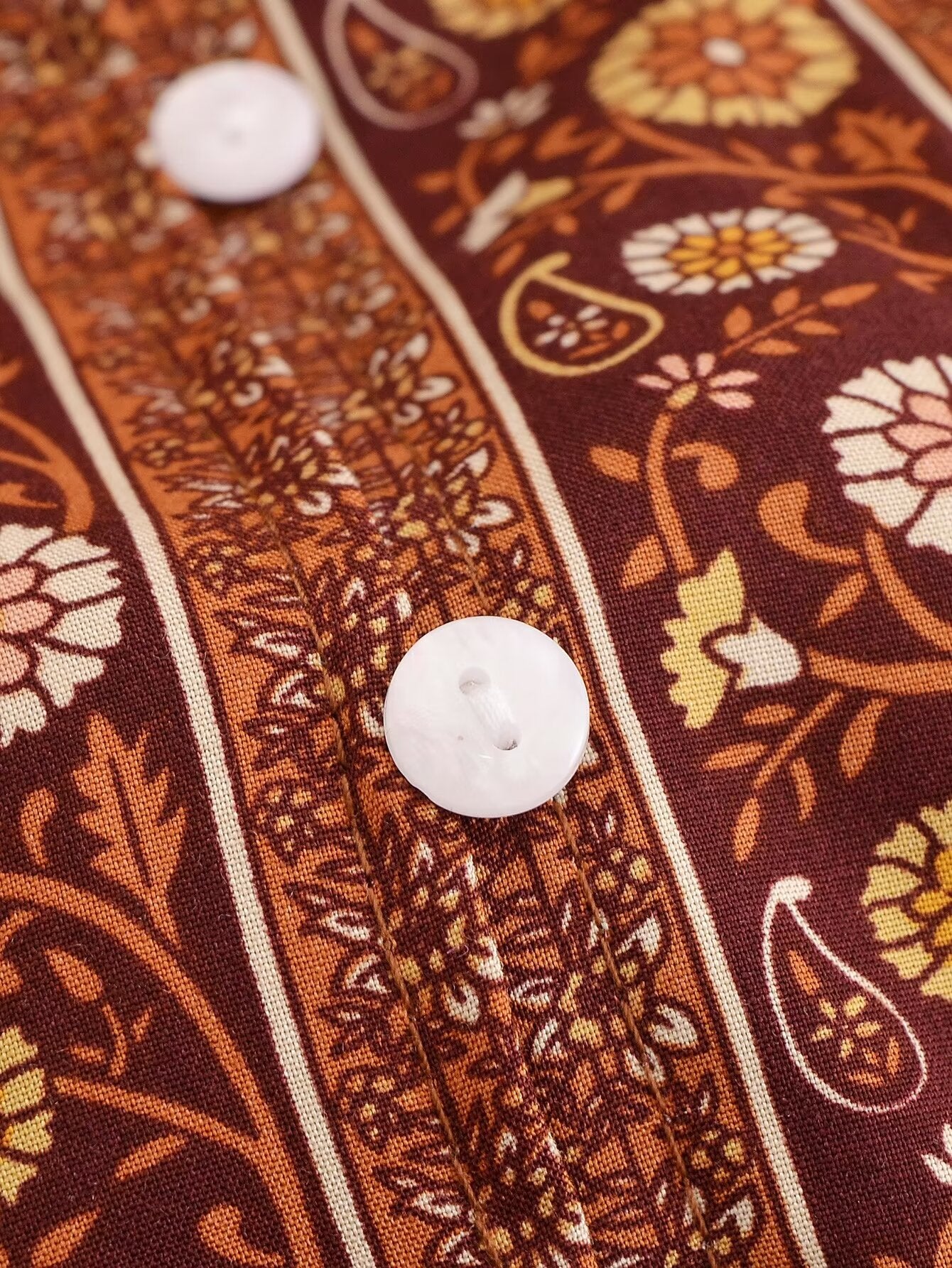 Close-up of printed rayon maxi dress for women featuring white buttons and intricate floral patterns