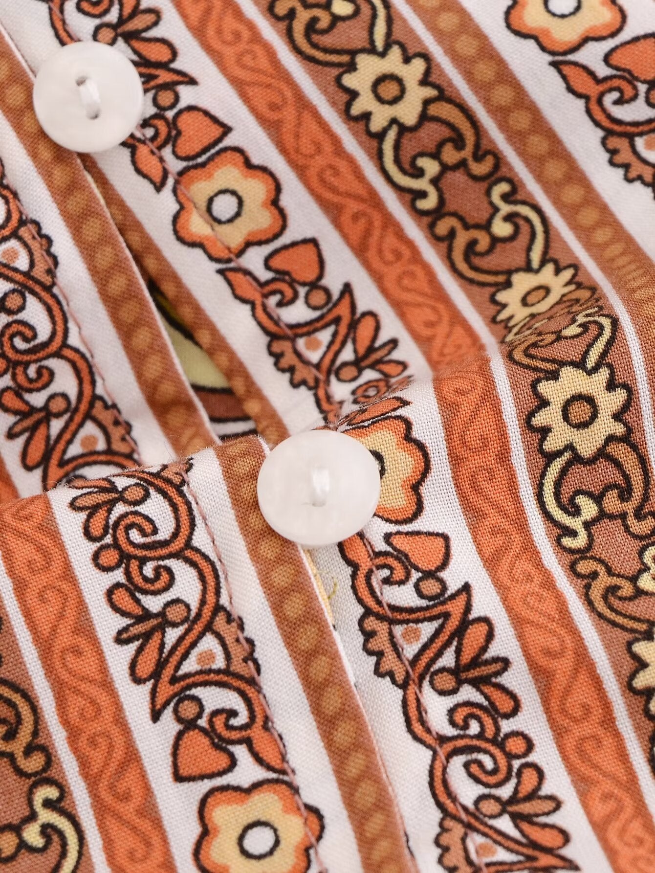 Close-up of Malbusaat rayon printed long sleeve dress fabric with floral patterns and white buttons