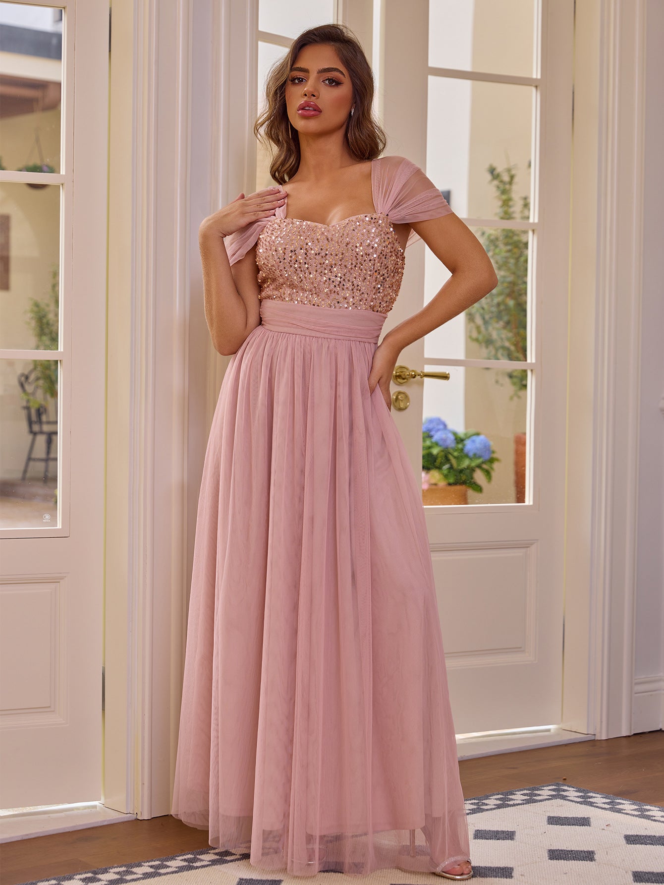 Elegant pink sequined short sleeved dress with a flowing tulle skirt by Malbusaat
