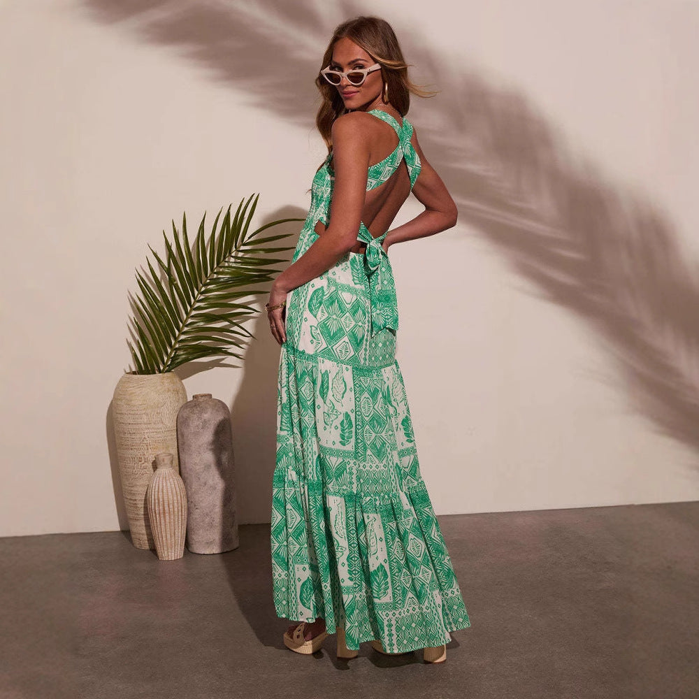 Woman wearing sleeveless floral printed maxi dress in green with back tie detail and sunglasses