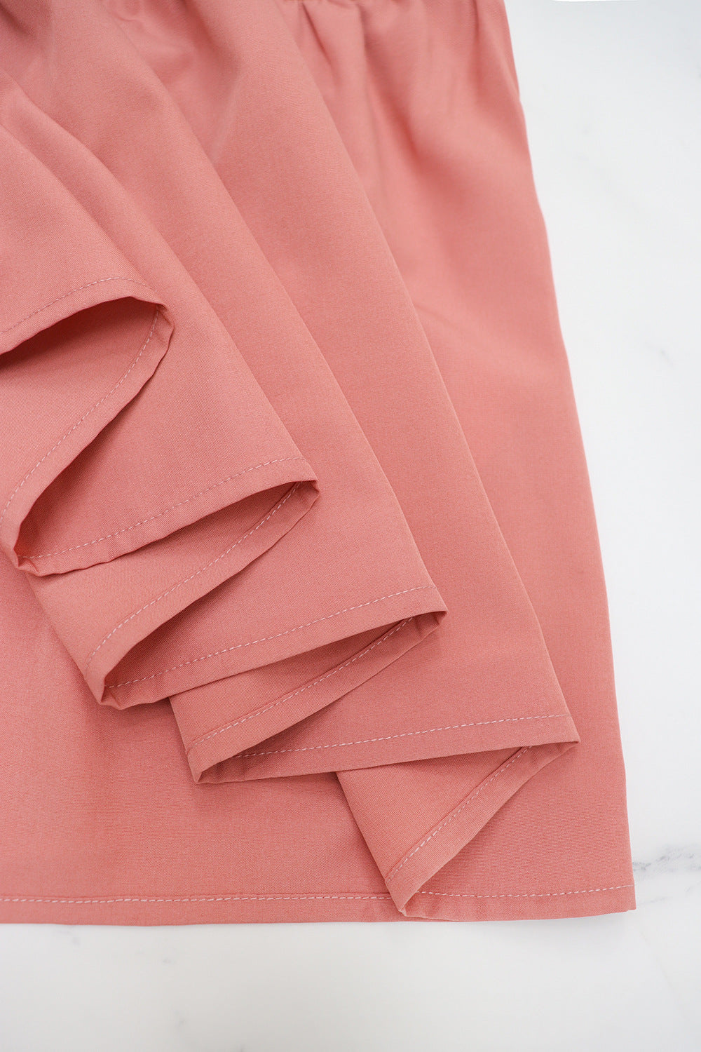 Close-up of soft fabric texture and stitching on Malbusaat solid v-neck maxi dress in pink