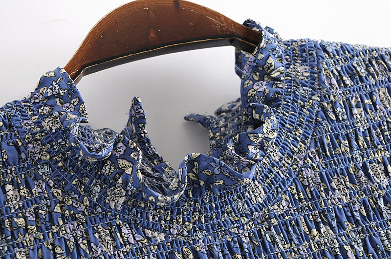 Close-up of Malbusaat summer maxi dress for women with blue floral smocked fabric and ruffled neckline