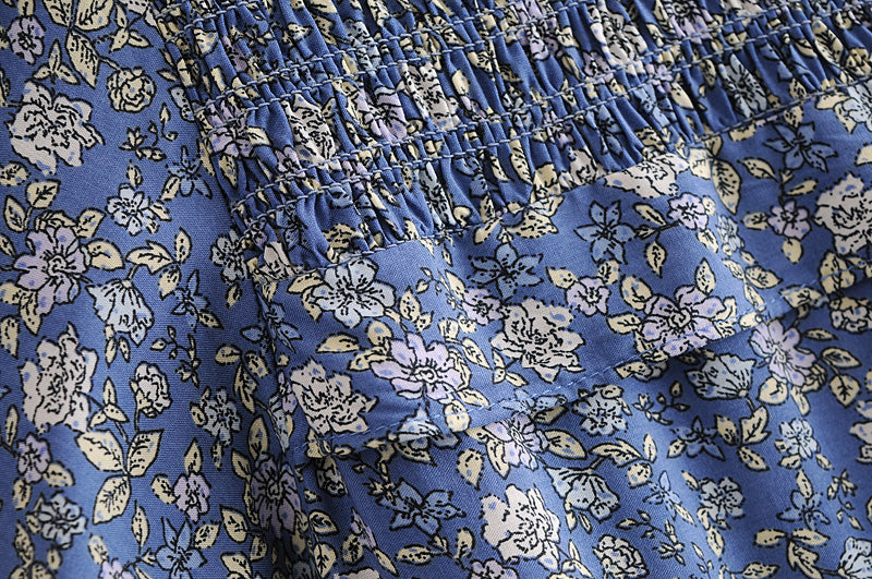 Close-up of blue floral fabric with gathered details on a summer maxi dress for women by Malbusaat