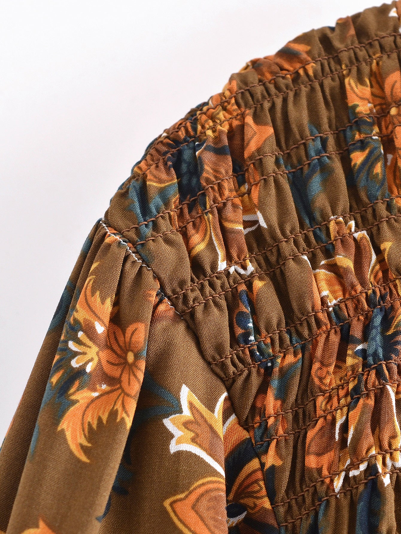 Close-up of Malbusaat summer printed midi dress fabric with floral pattern and smocked detailing