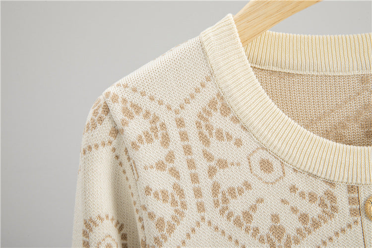Close-up of Malbusaat tassel button knit dress featuring a textured cream pattern and ribbed neckline