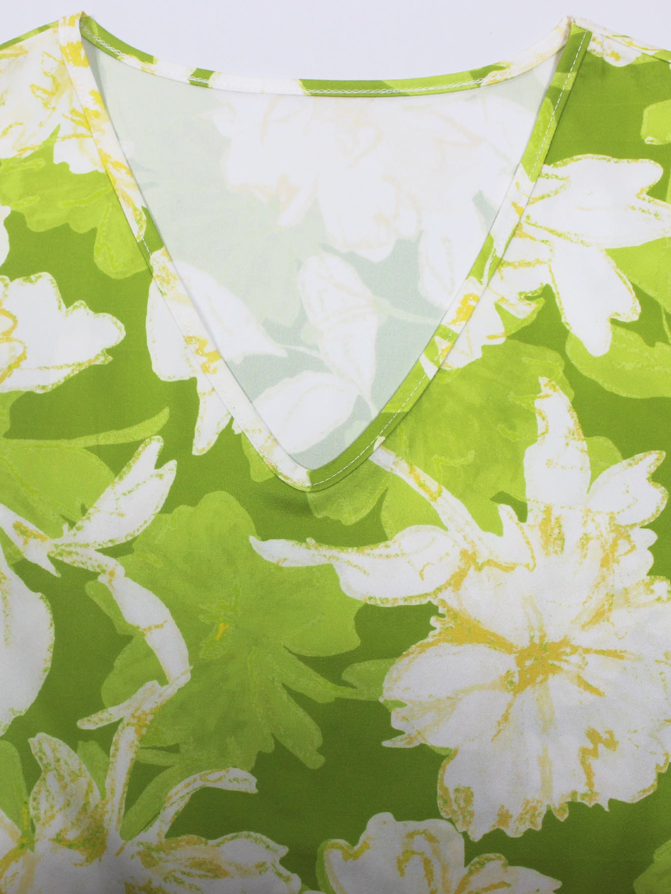 Close-up of green and white floral print short sleeved ladies jumpsuit outfit by Malbusaat